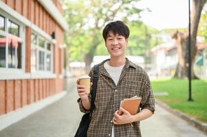 uma jovem homem Faculdade estudante, carregando uma mochila, carrinhos dentro frente do uma tijolo construção em campus. foto