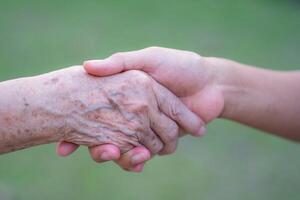 mão do uma avó segurando a mão do uma neta. encorajamento conceito foto