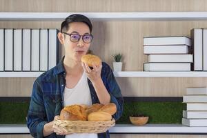 jovem homem em pé segurando uma pão e cesta às lar. espaço para texto. conceito do Comida e fresco padaria produtos foto