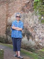 retrato do Senior mulher em tijolo fundo foto