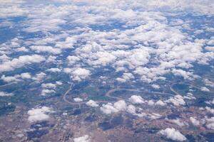 aéreo Visão do agrícola campo, rio, e nuvens estão visto através a avião janela foto