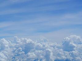 aéreo Visão do céu visto através a avião janela. brilhante azul céu e branco nuvens com Horizonte fundo. espaço para texto foto