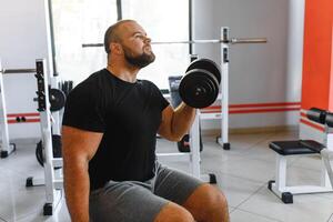 jovem bonito homem acionado dentro a academia. foto