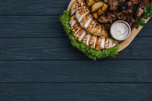 a maioria carne prato - carne kebabs, salsichas, grelhado cogumelos, batatas, tomates e molho. a melhor escolha para uma cerveja. fechar-se em uma de madeira fundo. foto