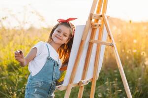 pequeno menina é pintura cenário ao ar livre. foto