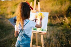 Educação, escola, arte e pintura conceito - pequeno aluna menina pintura cenário. foto