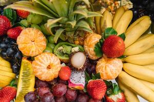 fresco orgânico frutas fundo. saudável comendo conceito. fresco, exótico, orgânico frutas, luz lanches dentro uma prato em uma bufê mesa foto