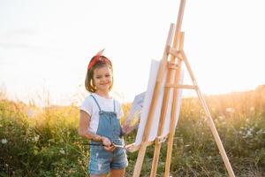 Educação, escola, arte e pintura conceito - pequeno aluna menina pintura cenário. foto