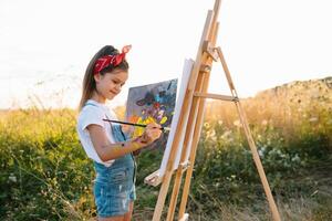 Educação, escola, arte e pintura conceito - pequeno aluna menina pintura cenário foto