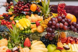 fresco orgânico frutas fundo. saudável comendo conceito. fresco, exótico, orgânico frutas, luz lanches dentro uma prato em uma bufê mesa foto