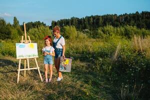 mãe ensina filha pintura dentro parque. ensolarado natureza, mãe e filha pintura uma cenário dentro uma parque , pintura uma pequeno criança, criança criatividade. mãe dia. foto