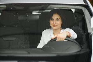 foto do feliz jovem mulher sentado dentro dela Novo carro. conceito para carro aluguel