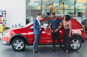 casal comprando a carro. senhora dentro uma carro salão. africano americano casal foto