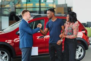 jovem africano casal comprando Novo carro às concessionária foto