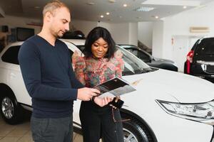 lindo jovem africano mulher comprando uma carro às concessionária foto