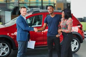 jovem africano casal comprando Novo carro às concessionária foto