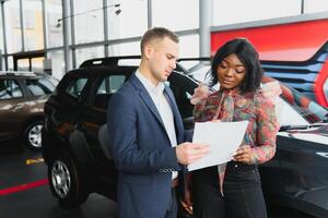 mulher comprando a carro. senhora dentro uma carro salão. elegante Preto menina foto