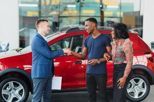 jovem africano casal comprando Novo carro às concessionária foto