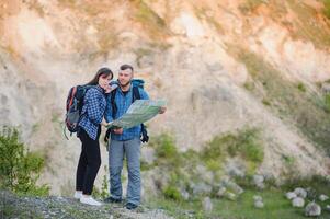 feliz romântico casal homem e mulher Viajantes com mochila segurando mãos montanhismo viagem estilo de vida e relação amor conceito montanhas panorama em fundo foto