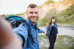 casal com mochilas levar selfie foto sobre montanha panorama caminhada, jovem homem e mulher em caminhar turistas aventura atividade