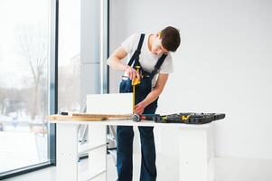 reparar, construção e construção conceito - feliz sorridente masculino trabalhador ou construtor dentro óculos às Novo casa em fundo foto