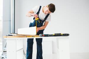 reparar, construção e construção conceito - feliz sorridente masculino trabalhador ou construtor dentro óculos às Novo casa em fundo foto