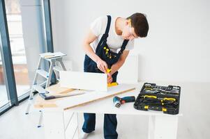 reparar, construção e construção conceito - feliz sorridente masculino trabalhador ou construtor dentro óculos às Novo casa em fundo foto