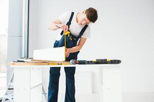 reparar, construção e construção conceito - feliz sorridente masculino trabalhador ou construtor dentro óculos às Novo casa em fundo foto