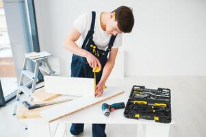 reparar, construção e construção conceito - feliz sorridente masculino trabalhador ou construtor dentro óculos às Novo casa em fundo foto