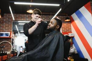 visitando barbearia. africano americano homem dentro uma à moda barbeiro fazer compras foto