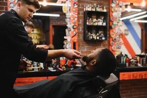 jovem afro-americano homem visitando barbearia foto