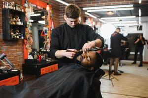 visitando barbearia. africano americano homem dentro uma à moda barbeiro fazer compras foto