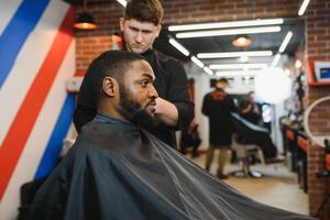 visitando barbearia. africano americano homem dentro uma à moda barbeiro fazer compras foto