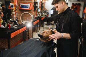 jovem afro-americano homem visitando barbearia foto