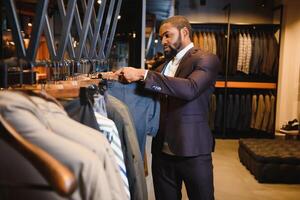 africano americano homem, roupas loja, escolhe roupas foto