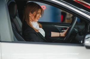 foto do feliz jovem mulher sentado dentro dela Novo carro. conceito para carro aluguel.