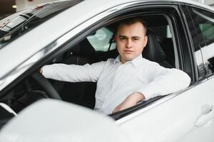 retrato do a bonito sorridente o negócio homem dirigindo dele carro. foto