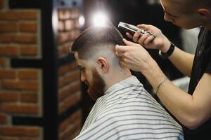 fechar-se, mestre cabeleireiro faz Penteado e estilo com tesouras e pentear. conceito barbearia foto