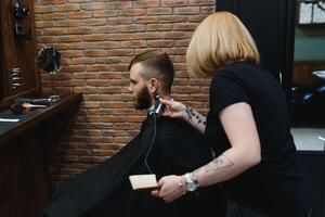 barbeiro mulher corte homem cabelo às a barbearia. mulher trabalhando Como uma cabeleireiro. pequeno o negócio conceito foto