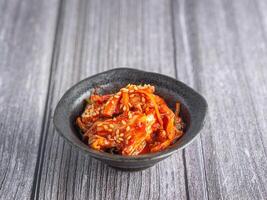 topo Visão do tradicional coreano pratos ou Kimchi dentro uma tigela em uma de madeira mesa. espaço para texto. conceito do coreano alimentos foto