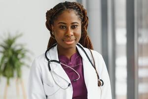 lindo africano americano enfermeira com braços guardada. foto