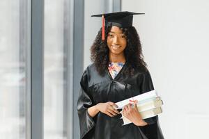 lindo africano fêmea aluna com graduação certificado foto