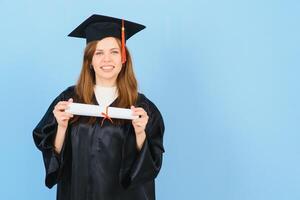 mulher graduado aluna vestindo graduação chapéu e vestido, em azul fundo foto