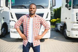 retrato africano masculino feliz sorridente confiante positivo perto caminhão. jovem homem xadrez camisa proprietário caminhão motorista dentro o negócio grandes transporte polegares acima satisfeito serviço comercial dirigindo licença Treinamento foto