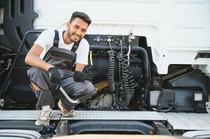 homem dentro uniforme. caminhão reparar. carro defeituoso foto