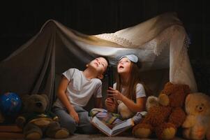 pequeno crianças lendo hora de dormir história às casa foto