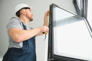 trabalhador da construção civil instalando janela em casa foto