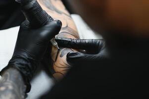 profissional tatuagem artista trabalhando dentro dele tatuagem estúdio. foto