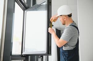 trabalhador da construção civil instalando janela em casa foto