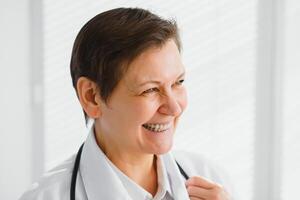 retrato do meio era fêmea médico é vestindo uma branco médico casaco com uma estetoscópio por aí dela pescoço. foto